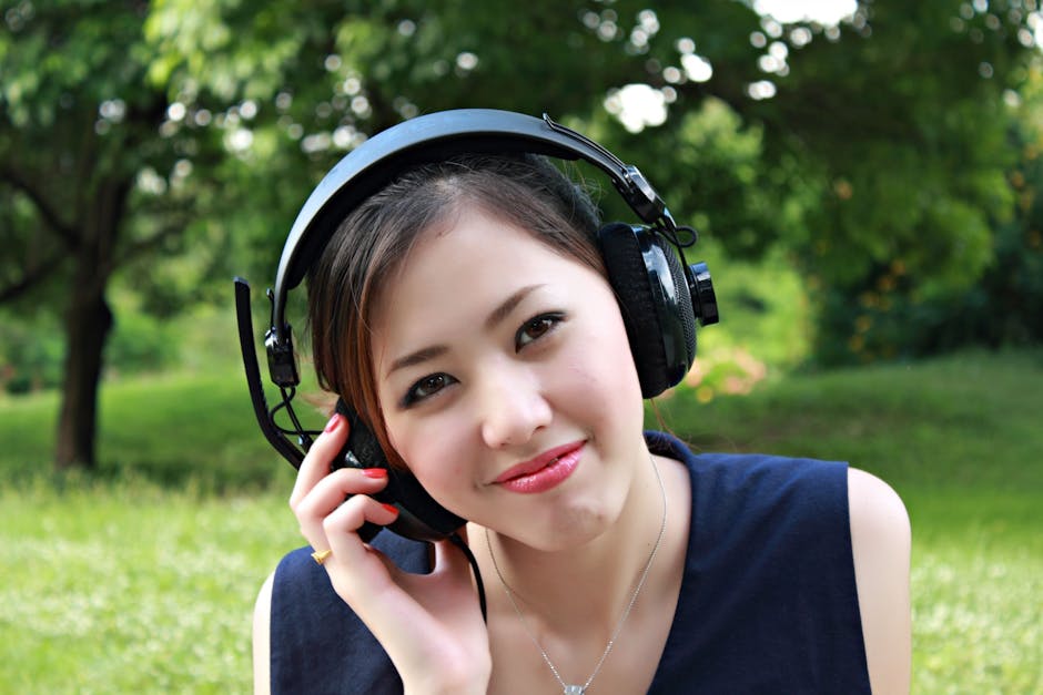 Woman Sitting on Ground While Using Headset